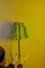 Man leaning a mop up against wall.