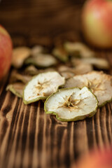 Apfel in Scheiben geschnitten und getrocknet im Herbst für den Winter als Vorrat auf einem Tisch aus Holz