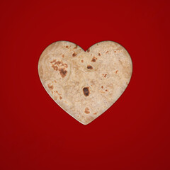Fototapeta premium roti or Ruti in shape of a heart on white background. Flat lay. Love concept. isolated, Valentine's day background. Flat lay, top view, template, copy space, minimal idea concept.14 February, food