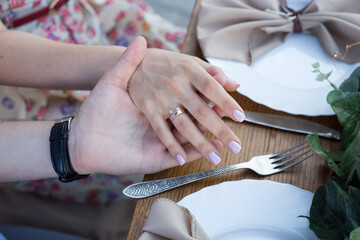 newlyweds hold hands over the table