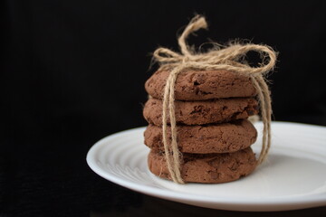 chocolate chip cookies on a plate on a black background