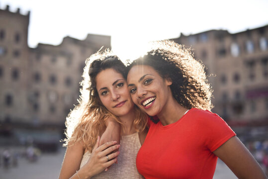 
two young women embraced in the street
