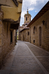 Fototapeta na wymiar Street of Santo Domingo de Silos with the tower of Monastery of SIlos in the background, Burgos, Spain