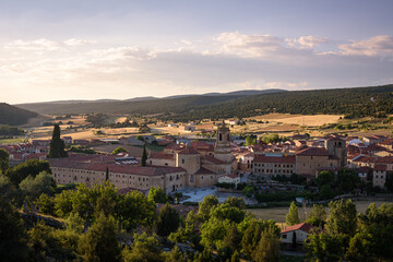 Fototapeta premium City landscape of Santo Domingo de Silos from a rock on the top of the hill and the Monastery of Silos in the city center at sunset, Burgos, Spain