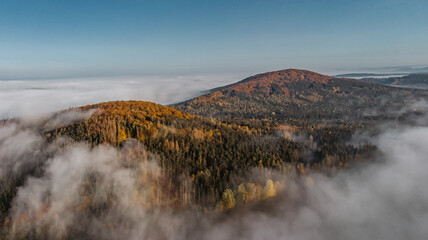 Aerial view of morning foggy landscape. Fall autumn peaceful scenery. Misty calm atmosphere. Drone photo of Czech mountain Velky Blanik. Trees in fog. Fairy tale land.Meditation dreamy concept.