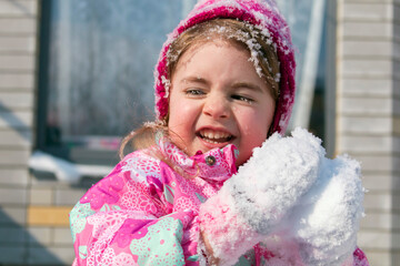Close up Portrait of cute little girl having fun in the snow