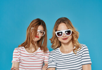 two cheerful girlfriends in striped t-shirts sunglasses hug friendship 