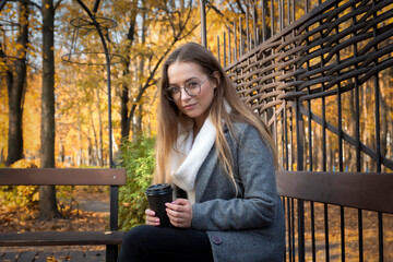 A young beautiful girl walks in the park on a sunny autumn day.