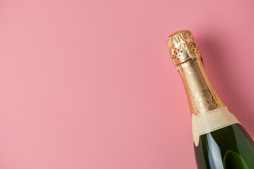 Champagne bottle on pink background with copy space for text. Object for new year, Christmas and...