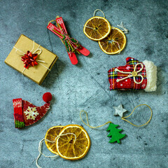 Christmas composition of handmade christmas tree toys made of fabric and wood, dried oranges, gift cardboard box laid out in the shape of a creative christmas tree , top view flat lay, square