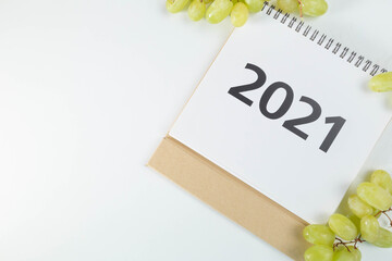 calendario 2021 tumbado en una esquina rodeado por uvas