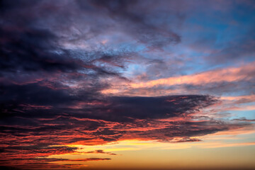 Clouds are painted with dramatic and vivid colors in the evening sky just after a beautiful sunset.