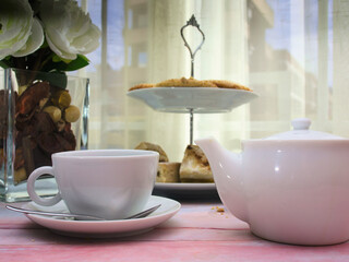 Tea and spanish christmas candies as cortadillos and cakes on pink marble table