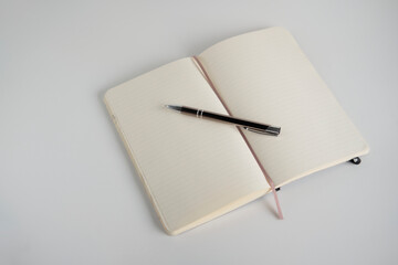 Notebook and pen on a white desk