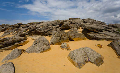 heap of huge stones lie on a sand, stony desert landscape