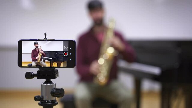 Music teacher recording class for remote learning from home. Music Schools Online education in times of Coronavirus