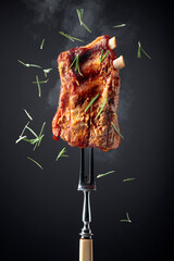 Grilled pork ribs on a fork.