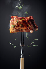 Grilled pork ribs on a fork.