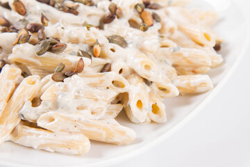 Pasta with blue cheese and cream sauce, sprinkled with roasted pumpkin seeds