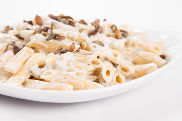 Pasta with blue cheese and cream sauce, sprinkled with roasted pumpkin seeds