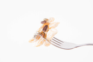 Pasta with blue cheese and cream sauce, sprinkled with roasted pumpkin seeds eaten with a fork