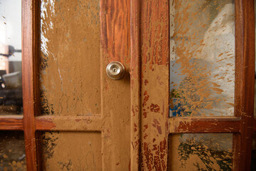 
dirty wood and glass door with dirt