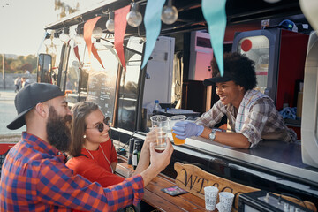 afro-american female employee socializing with caucasian couple, having a toast