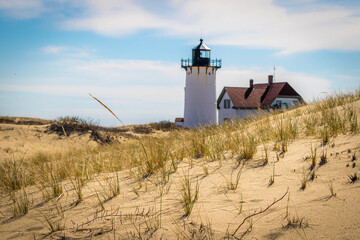 Fototapeta na wymiar A lighthouse beyond the sand dunes on Cape Cod
