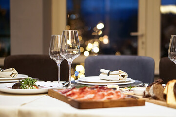 Nicely served New Year's table in the restaurant. Christmas night in a cafe or at home. Stock photo for design