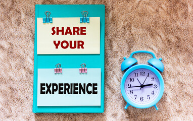 Share your experience written on stickers beside the alarm clock on the sand background