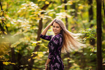 Fototapeta na wymiar girl with long hair walks in the park in autumn
