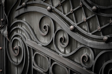 Rustic metal gates with forged elements, home protection in a retro style