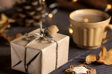 Gift box decorated with acorn and a cup of coffee. Winter mood.