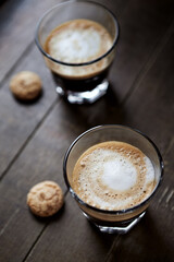 Two Glasses Of Coffee with Milk on dark wooden background.