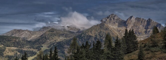 Scenic mountain landscape with mountain peaks fog,cloudy sky,rocks, trees.Mystique relaxing nature.panoramic photo.September,Schladming Tauern,Alps,Austria .