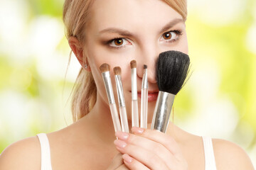 blonde Frau hält Make-up Pinsel