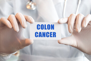 Doctor holding a card with text COLON CANCER, medical concept