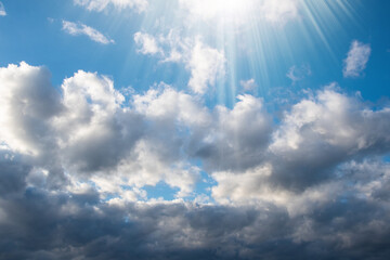 Naklejka na ściany i meble Blue sky background with white dramatic clouds and sunlight, sky background