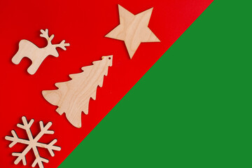 Flat natural unpainted wooden christmas decorations on red and green diagonal background
