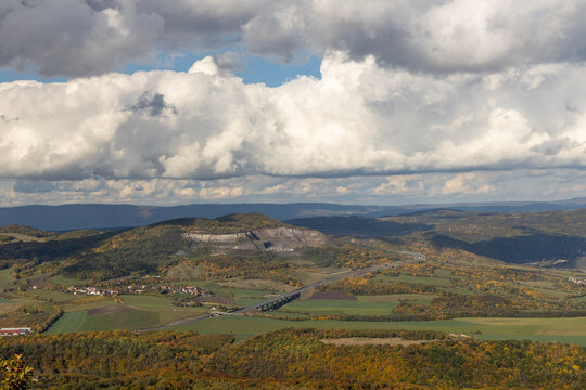 Autumn nature view from mountain Lovos to the horizon with hills and mountains and stone pit and cloudy sky