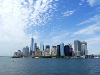 Fototapeta na wymiar View of Manhattan skyline from the sea with cloudy blue sky
