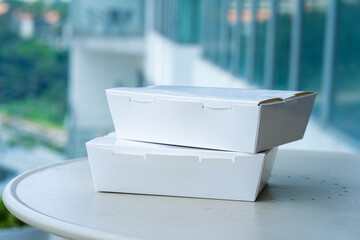 White cardboard boxes with food on the table. Food delivery