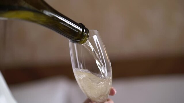 Pouring champagne from bottle to glass. Alcohol drink sparkling wine beverage