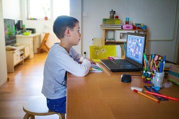 Child at home having remote school on laptop computer. - obrazy, fototapety, plakaty