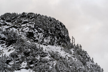 Rocky Snow Covered Peak Stands in Contrast Against Cloudy Sky