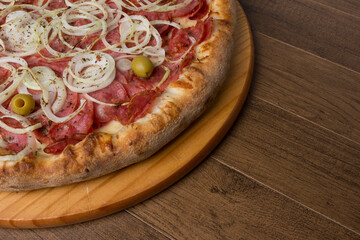 Pepperoni pizza, slices of onions, mozzarella cheese and green olives. Close-up photography of gastronomy. Right space for texts.