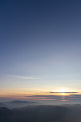 Autumn sunset above foggy hills
