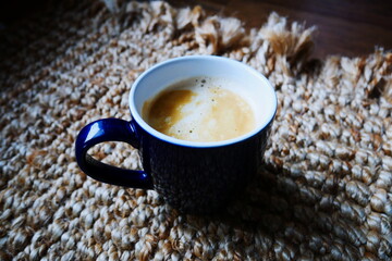 Cup of coffee with crema on a rug