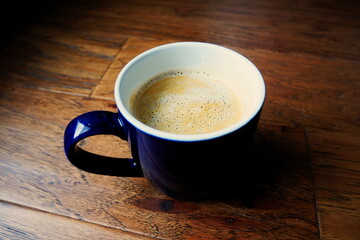 Cup of coffee with crema on a wooden suface