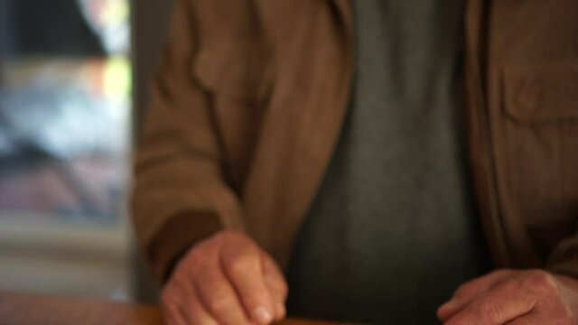 Close-up of a mansface and hands counting money savings due to economic financial crisis and unemployment looking at phone with currency rates and a calculator, income decrease